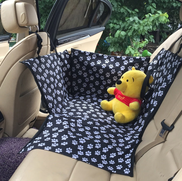 Car seat protector cover, black with white paw-print pattern for back seat.