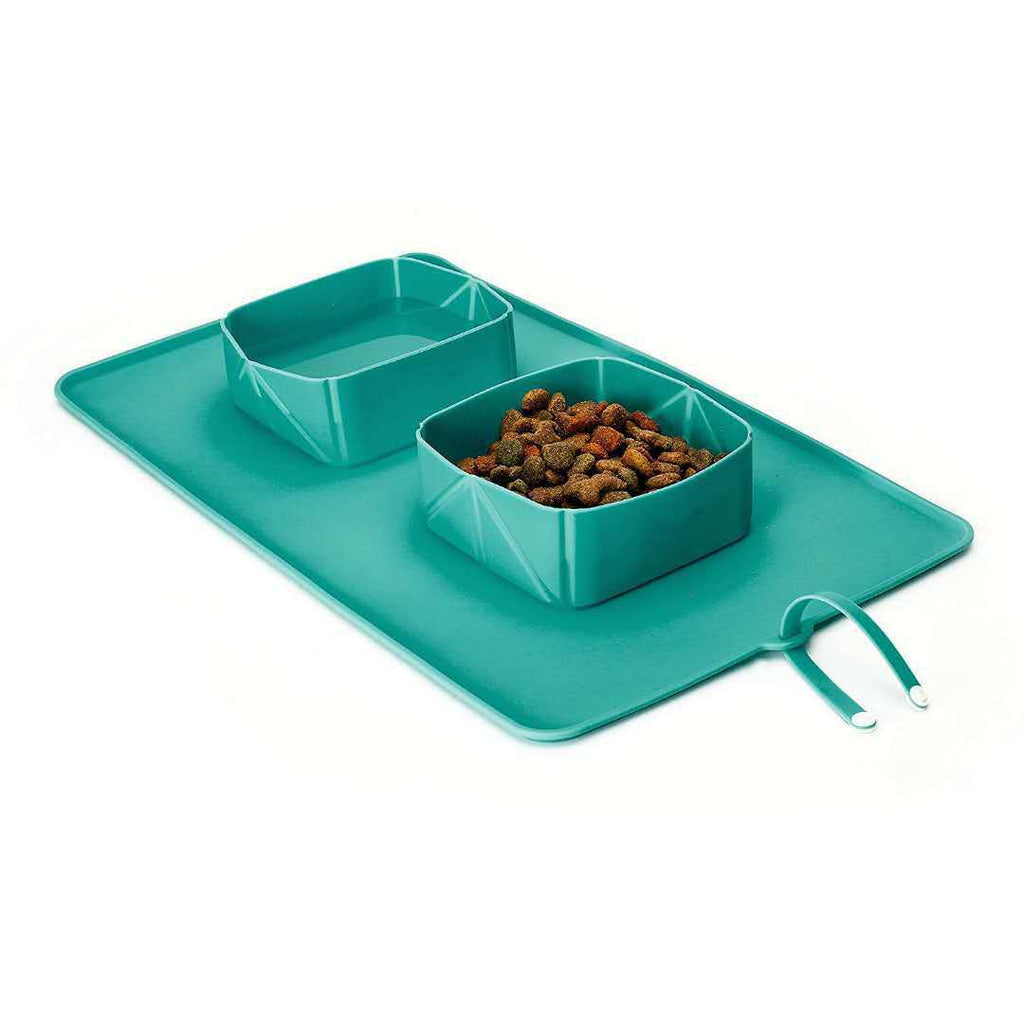 Turquoise two-compartment silicone pet bowl on foldable mat with carry loop