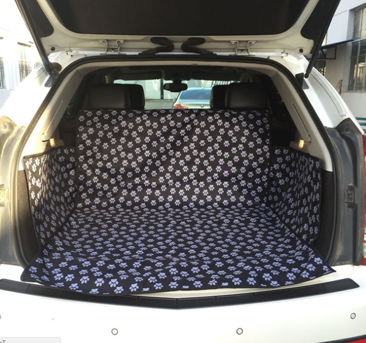 Car seat protector cover, black with white paw-print pattern fitted to rear seats.