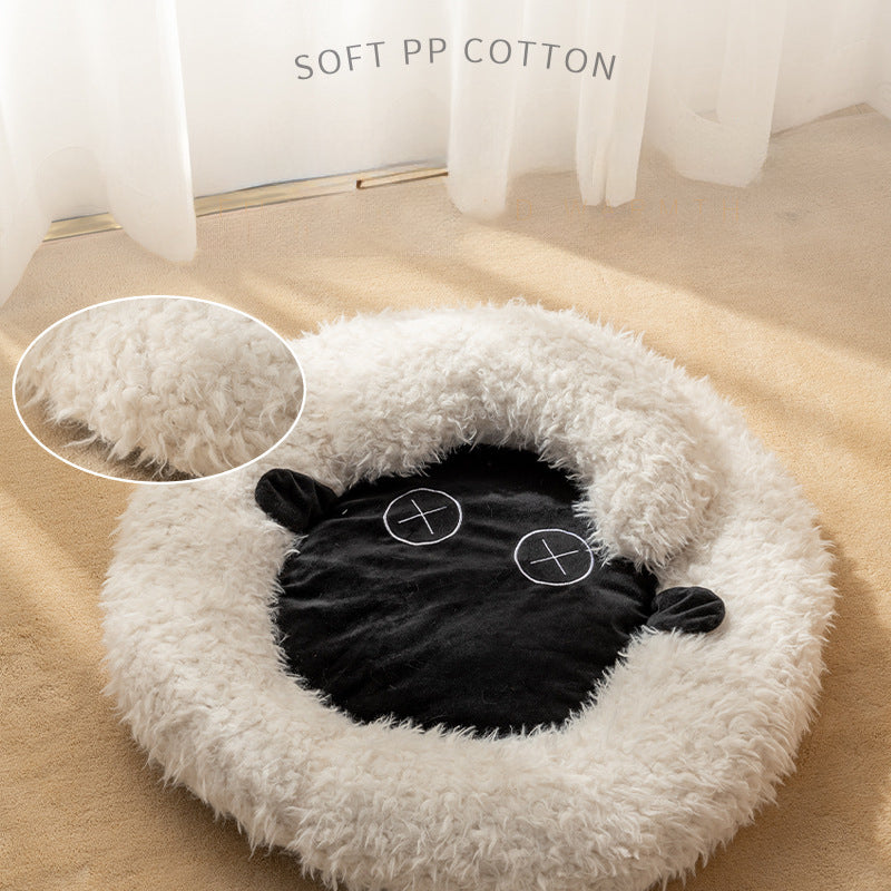Round plush pet bed with black sheep face applique and embroidered accents on beige