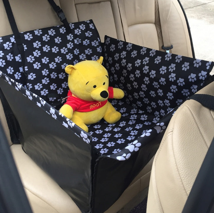 Car seat protector cover, black with white paw-print pattern and padded fit.