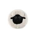 Round plush pet bed with black sheep face applique on light beige cushion