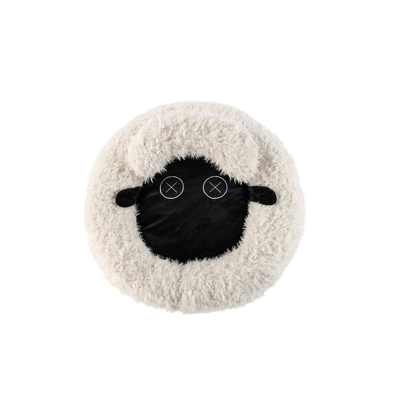 Round plush pet bed with black sheep face applique on light beige cushion